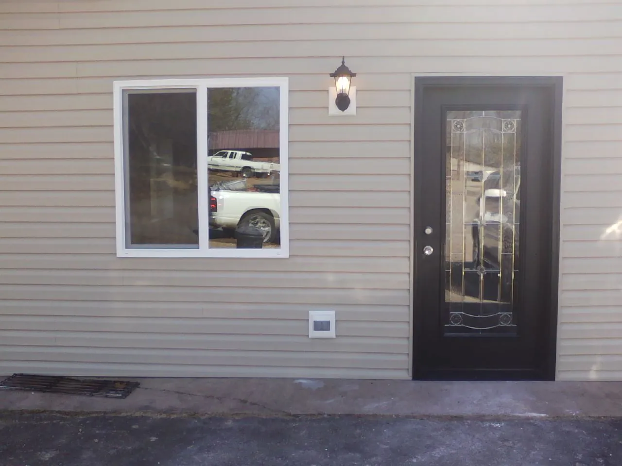 New siding, window and entry door on the side of an addition in Bonneau