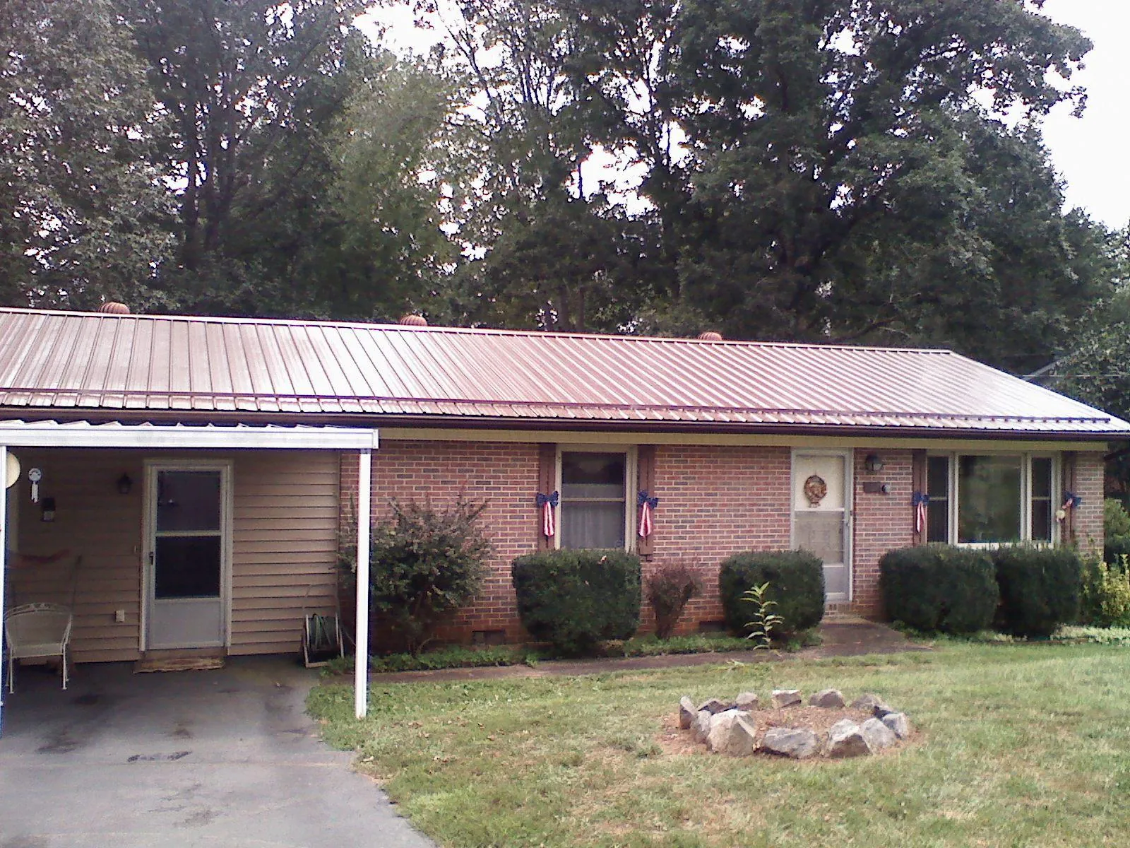 Bronze metal roof and carport on a brick ranch home — Roof Repair work by our crew in Bonneau