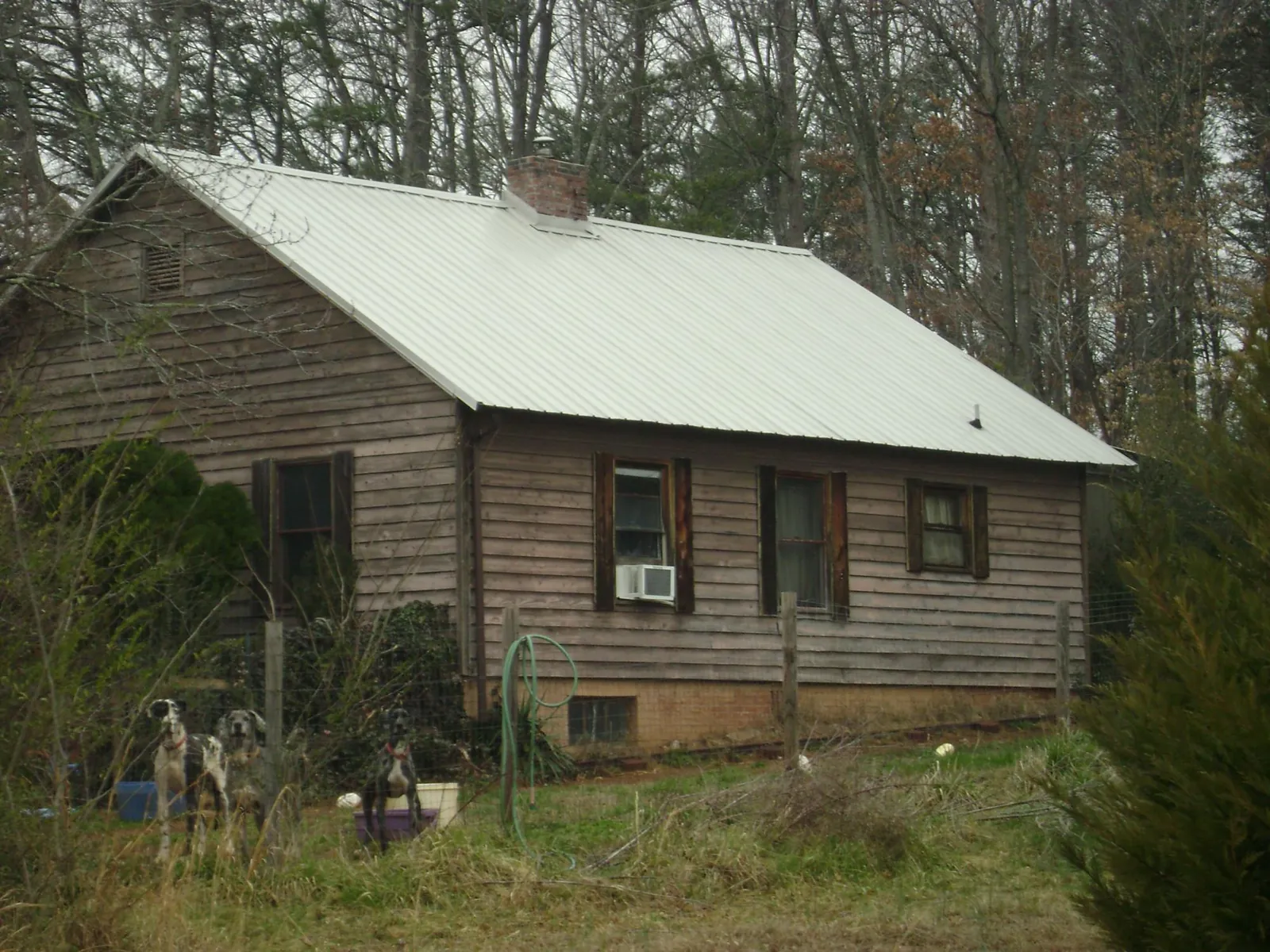 White metal roof on an old wood sided farmhouse, from a Metal Roof Installation job in Bonneau